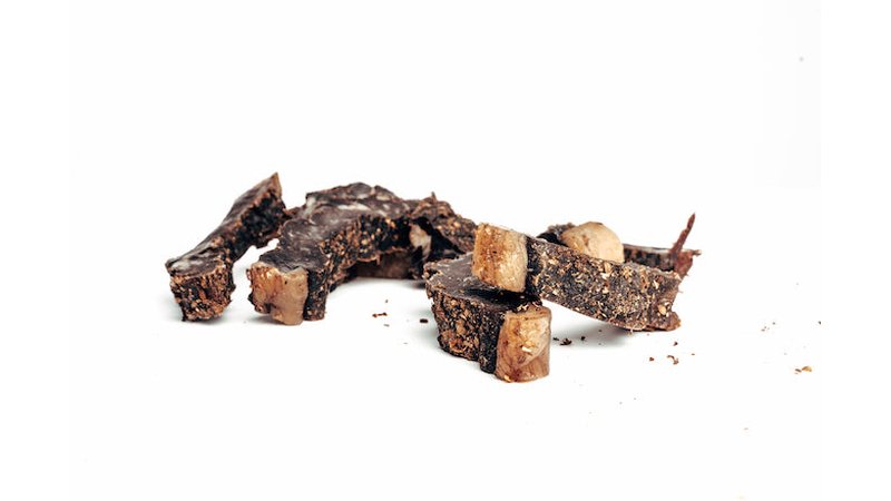 Thick slices of chilli biltong stacked on a white background
