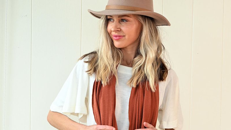 A woman in an ivory merino top with a cinnamon luxury scarf